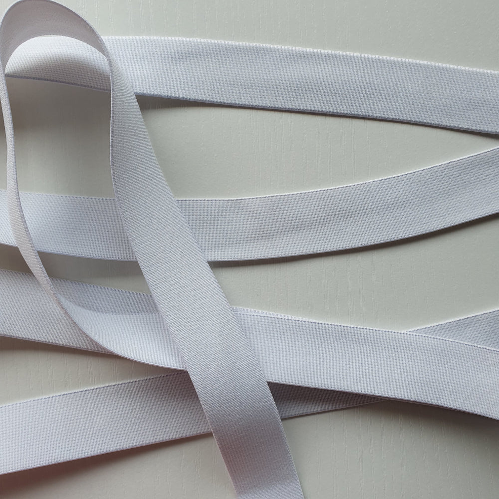 White 25mm high density non-roll elastic arranged on a plain white background.