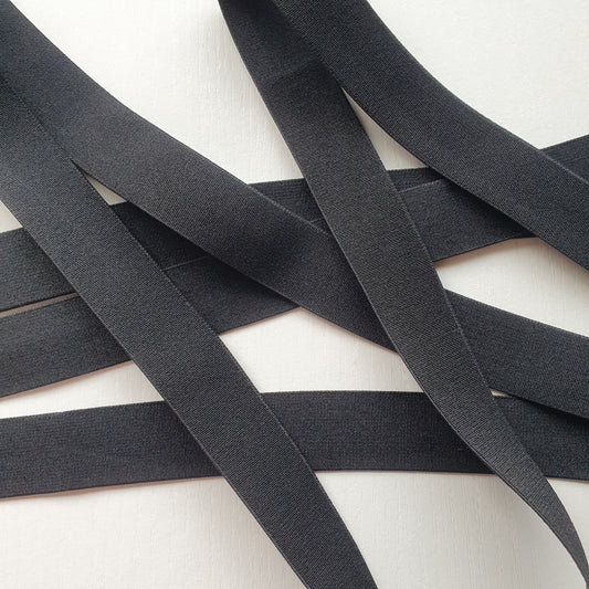 Black 25mm high density non-roll elastic arranged on a plain white background.