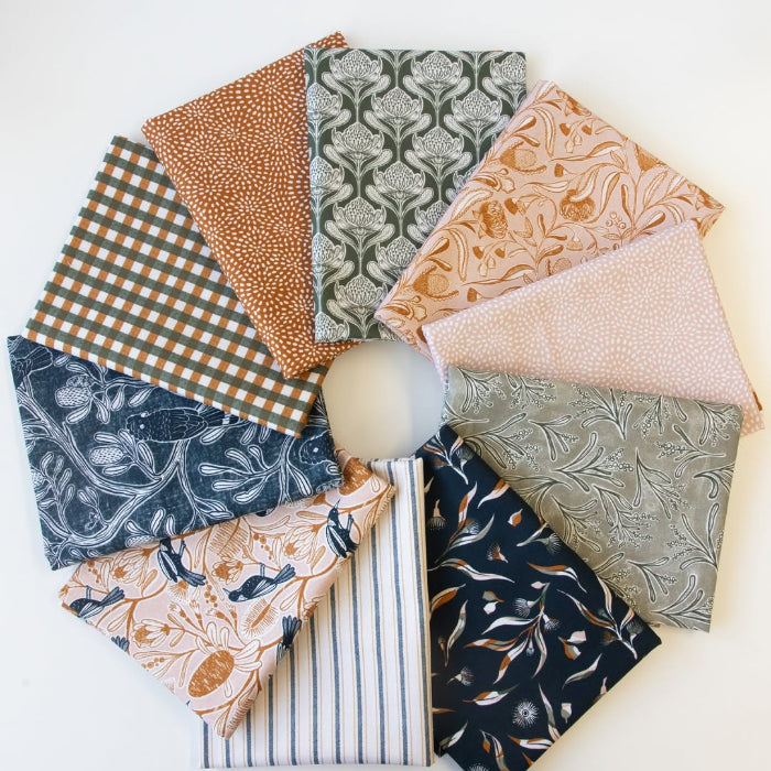 A circular arrangement of ten folded fabric squares in various patterns and colors, including gingham, damask, stripes, and botanical prints, displayed on a clean white background.